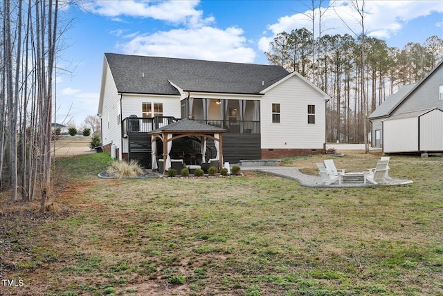 back of property featuring an outdoor fire pit, a sunroom, crawl space, a yard, and a gazebo