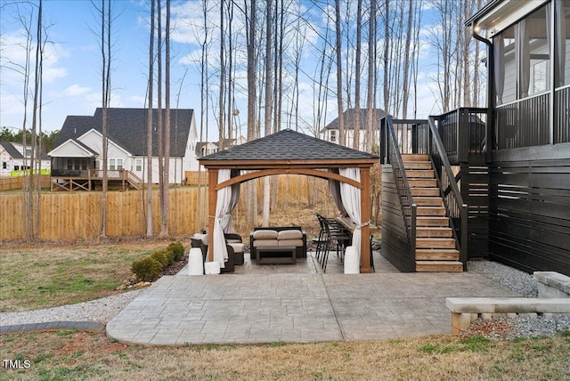 view of patio featuring fence, stairway, outdoor lounge area, and a gazebo