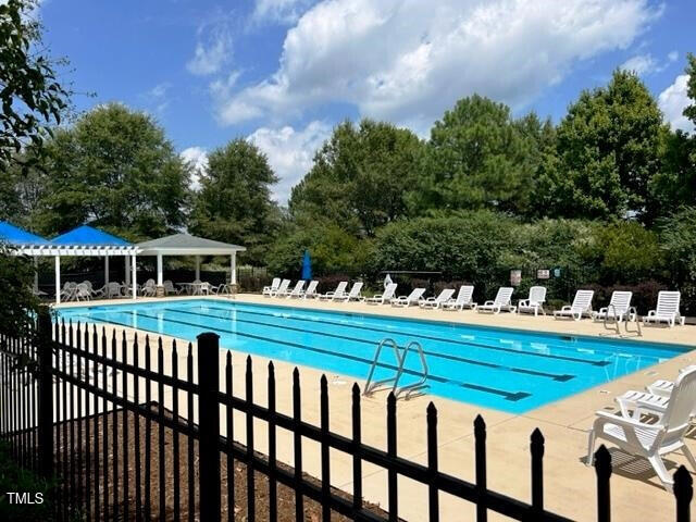 community pool featuring a patio area, fence, and a pergola