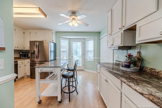 kitchen with stainless steel refrigerator with ice dispenser, light wood-style flooring, white cabinetry, a textured ceiling, and dishwasher