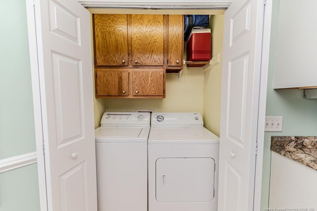 clothes washing area with cabinet space and independent washer and dryer