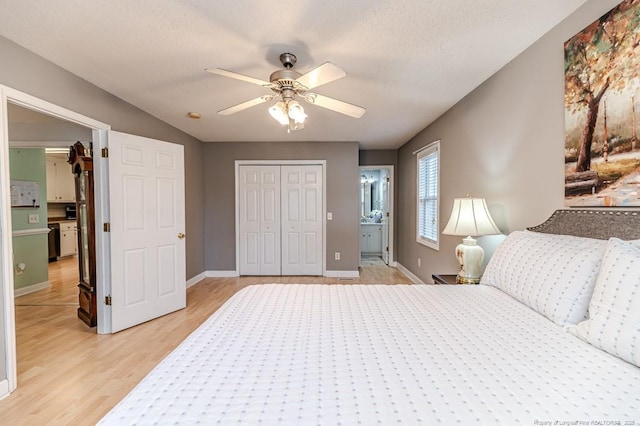 bedroom with a closet, light wood-style floors, a ceiling fan, a textured ceiling, and baseboards