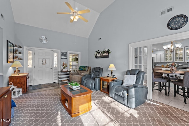 living area with high vaulted ceiling, visible vents, and ceiling fan with notable chandelier