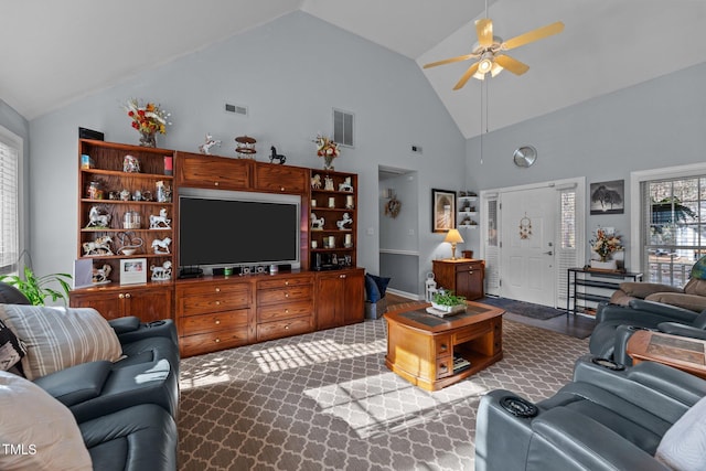 living area with a ceiling fan, visible vents, dark carpet, and high vaulted ceiling