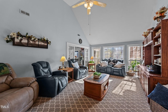 living room featuring high vaulted ceiling, dark carpet, visible vents, and a ceiling fan