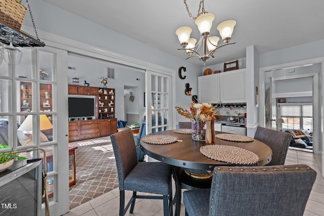 dining room with french doors, light tile patterned floors, visible vents, and an inviting chandelier