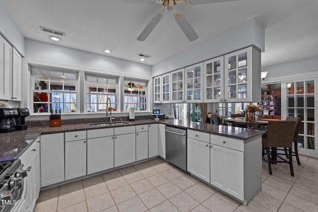 kitchen with light tile patterned floors, stainless steel appliances, visible vents, glass insert cabinets, and a sink