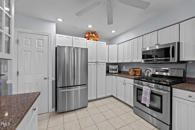 kitchen with white cabinetry, appliances with stainless steel finishes, dark stone countertops, and light tile patterned flooring