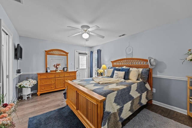 bedroom featuring light wood-style floors, visible vents, ceiling fan, and baseboards