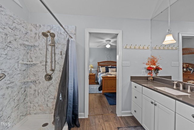 bathroom featuring a stall shower, vanity, ensuite bath, and wood finished floors