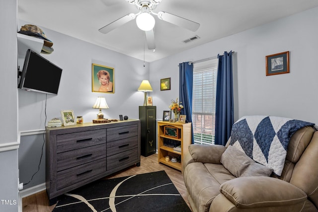 sitting room featuring light wood-type flooring, ceiling fan, and visible vents