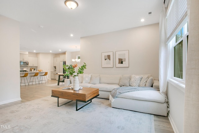 living room featuring light wood finished floors, recessed lighting, and a wealth of natural light