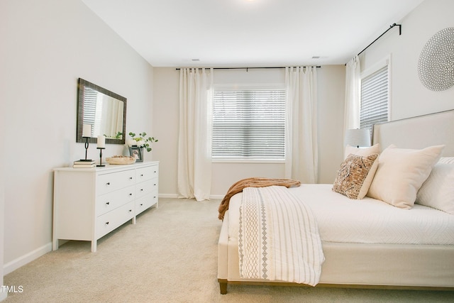 bedroom featuring light carpet and baseboards