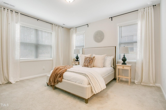 bedroom featuring visible vents, multiple windows, carpet, and baseboards