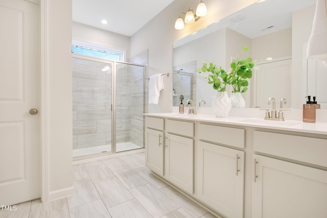 full bathroom with a sink, double vanity, and a shower stall