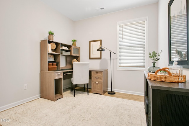 office space with visible vents, light wood-style flooring, and baseboards