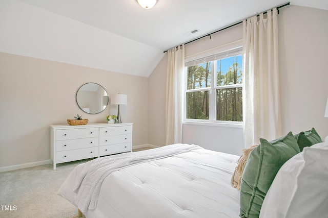 carpeted bedroom featuring vaulted ceiling, baseboards, and visible vents