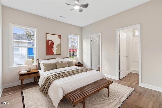 bedroom with light wood-style floors, visible vents, baseboards, and a ceiling fan