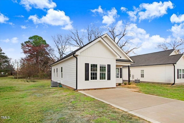 view of front of home with a front yard and central AC unit