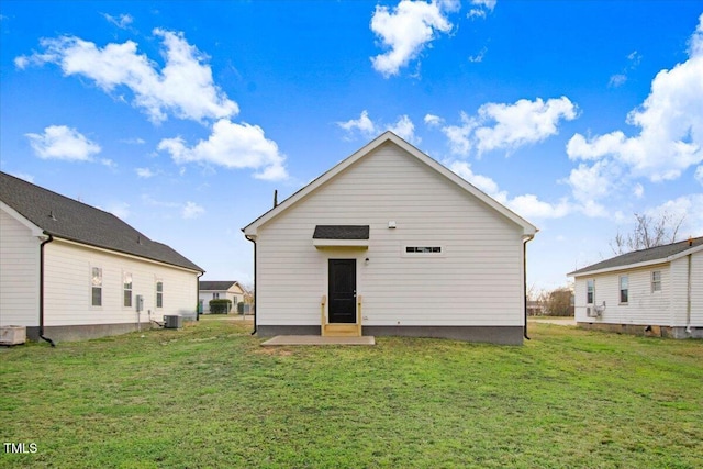 rear view of house featuring central AC and a yard