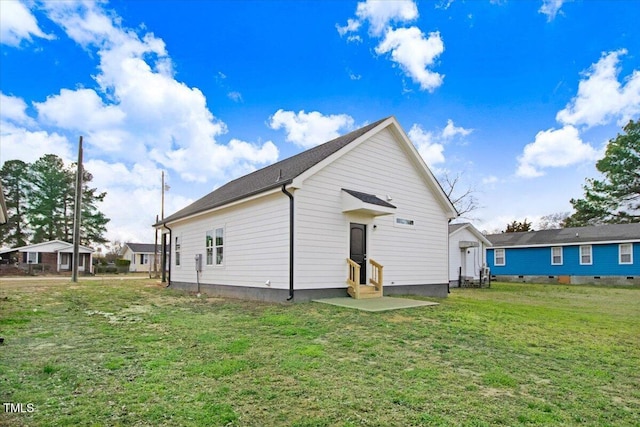 back of house featuring entry steps and a yard