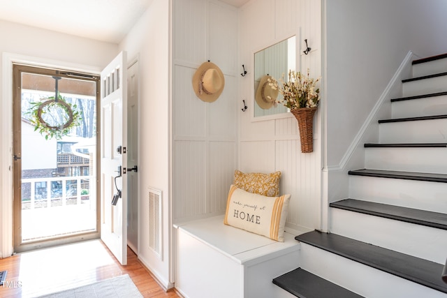 foyer with visible vents, light wood-style floors, and stairs