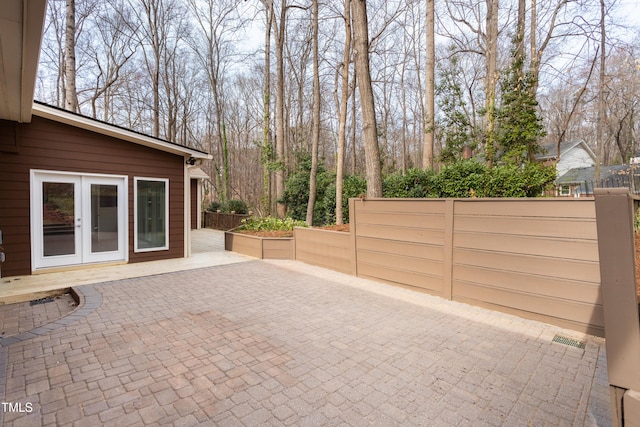 view of patio with french doors and fence