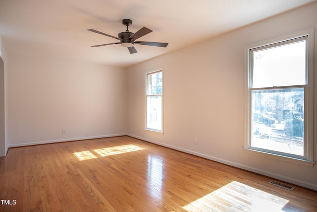 spare room featuring visible vents, baseboards, light wood-style floors, and ceiling fan