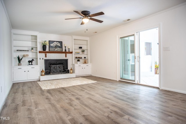 unfurnished living room featuring visible vents, crown molding, ceiling fan, light wood-style flooring, and a fireplace