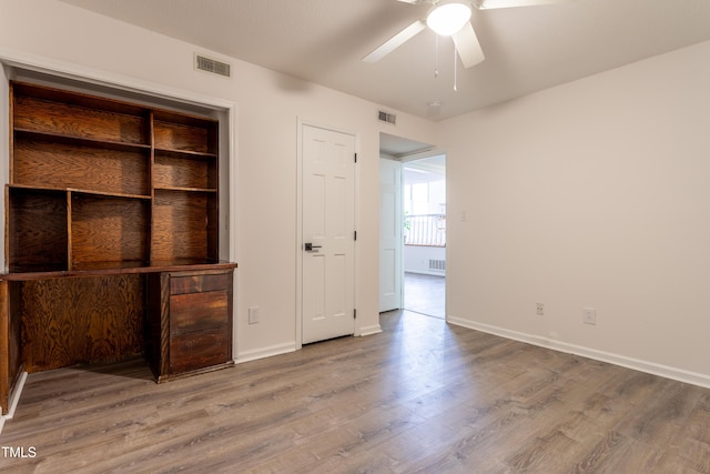 unfurnished bedroom with wood finished floors, visible vents, and baseboards