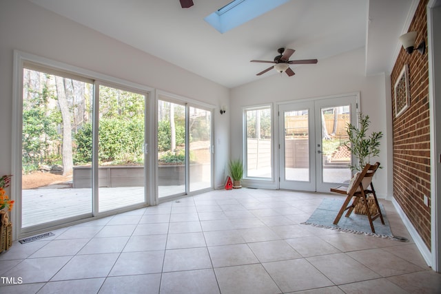 unfurnished sunroom with lofted ceiling with skylight, visible vents, french doors, and a ceiling fan