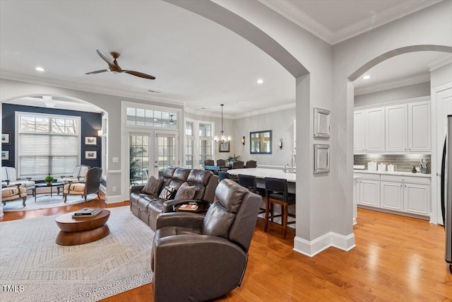 living room with crown molding, recessed lighting, baseboards, and light wood finished floors