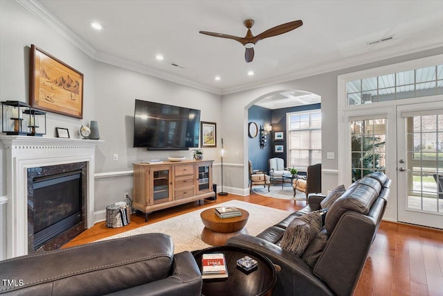 living area with visible vents, french doors, crown molding, and wood finished floors