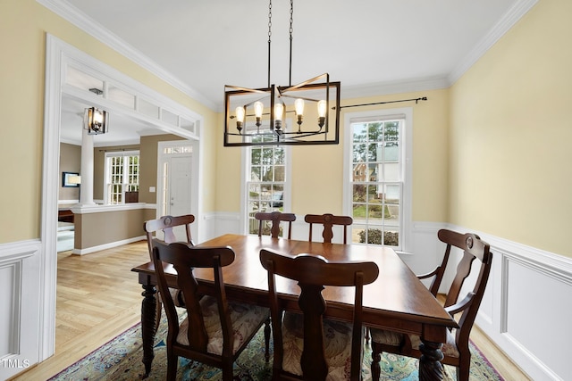 dining area with a wealth of natural light and a wainscoted wall