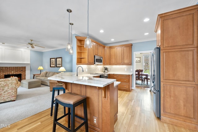 kitchen featuring a breakfast bar, open shelves, a peninsula, ornamental molding, and stainless steel appliances