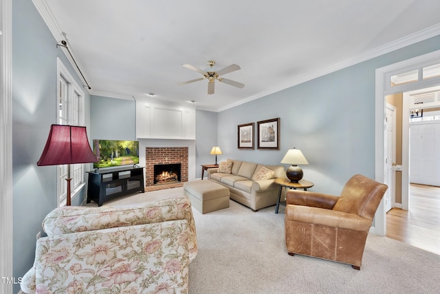 carpeted living area with a healthy amount of sunlight, a fireplace, and ornamental molding