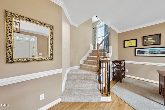 staircase featuring crown molding, baseboards, and wood finished floors