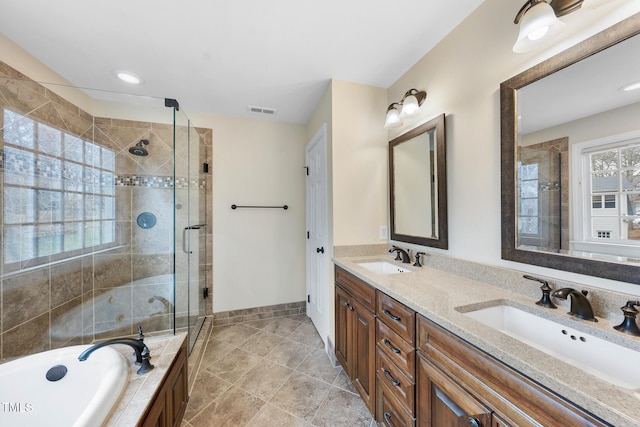 full bathroom featuring a sink, visible vents, a bathtub, and a shower stall