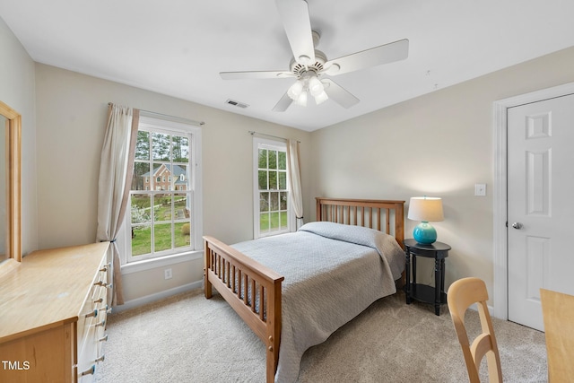 bedroom with light carpet, visible vents, multiple windows, and ceiling fan