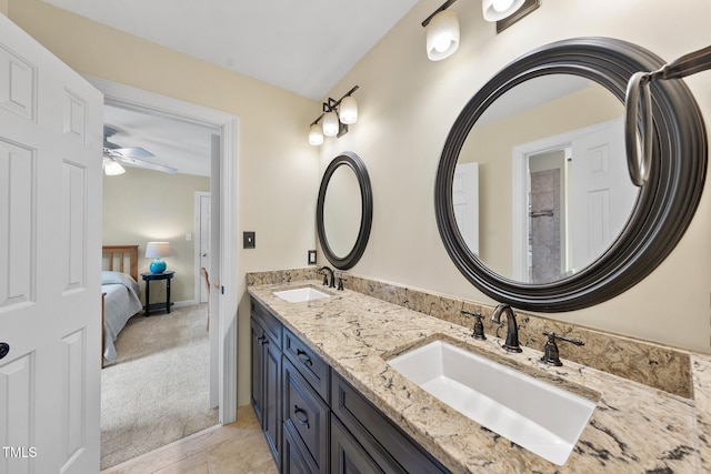 ensuite bathroom with a sink, a ceiling fan, double vanity, and tile patterned flooring