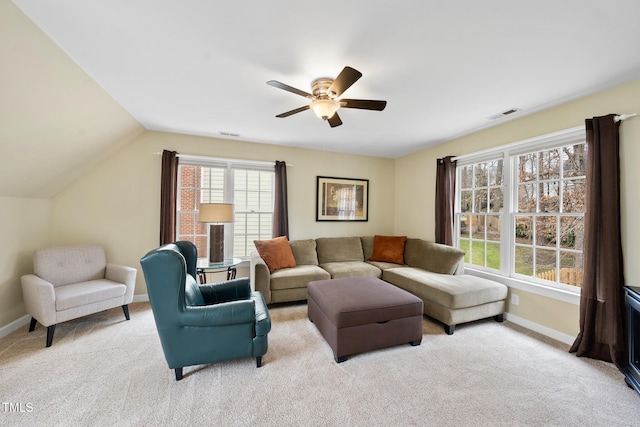 living room featuring visible vents, baseboards, light colored carpet, and vaulted ceiling