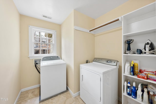 laundry area featuring washer and dryer, visible vents, baseboards, and laundry area