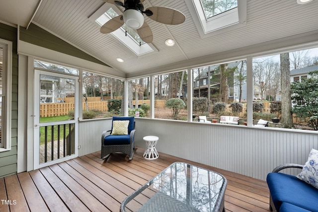 sunroom with vaulted ceiling with skylight and a ceiling fan