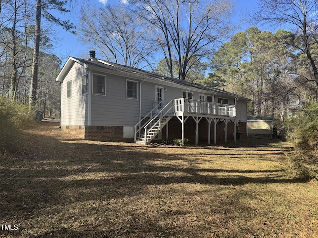 back of property featuring stairway, crawl space, a wooden deck, and a lawn