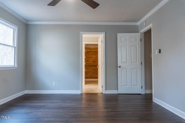 unfurnished room with dark wood-type flooring, ornamental molding, a textured ceiling, and baseboards