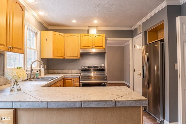 kitchen with a peninsula, stainless steel appliances, a textured ceiling, under cabinet range hood, and a sink