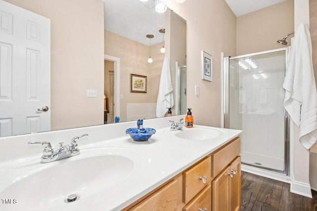 full bathroom with wood finished floors, a stall shower, and a sink