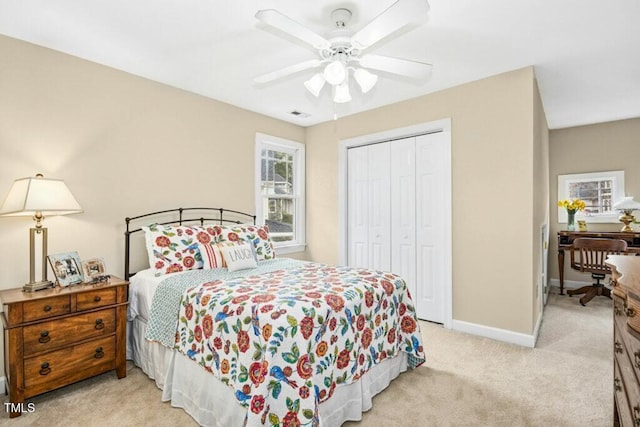 bedroom with visible vents, baseboards, ceiling fan, light colored carpet, and a closet