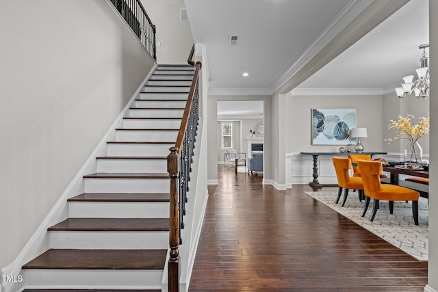 stairs featuring ornamental molding, wood finished floors, recessed lighting, baseboards, and a chandelier