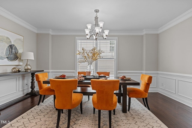 dining room with an inviting chandelier, ornamental molding, dark wood-style flooring, and wainscoting